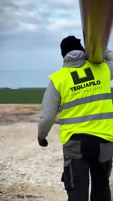 Annessi agricoli a Zapponeta: operaio Tegliafilo trasporta una tubazione in cantiere