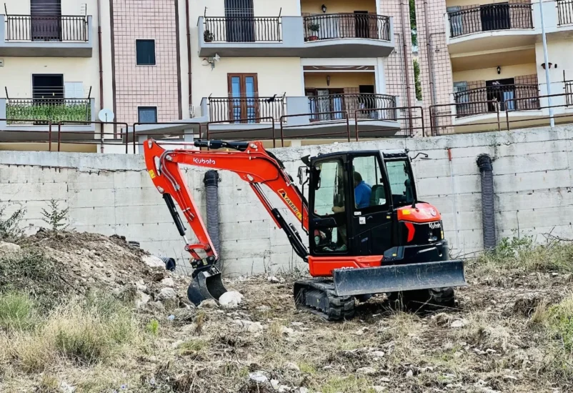 Rete idrica e fognaria a Monte Sant'Angelo: miniescavatore al lavoro sotto le abitazioni