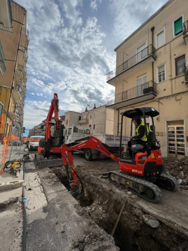 Risanamento idrico a Monte Sant'Angelo: miniescavatore nello scavo lungo la via